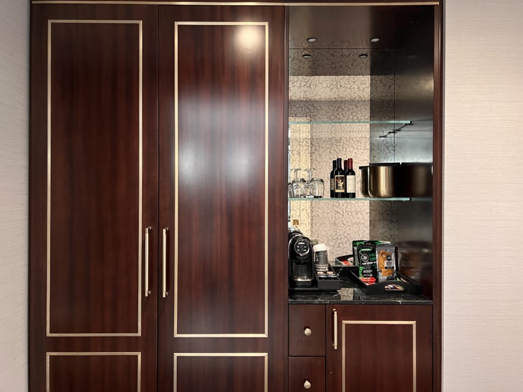 a cabinet with a shelf and coffee cups