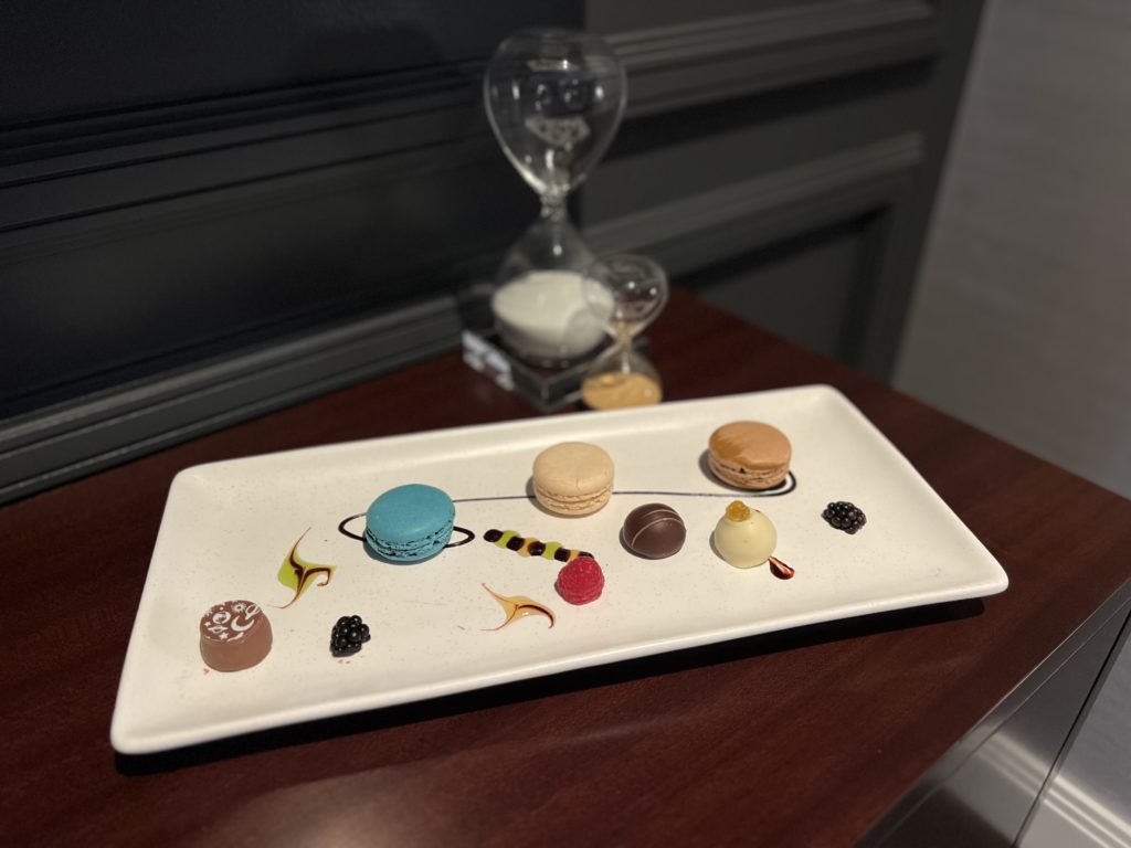 a plate with cookies and sandglasses on a table