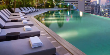 a pool with lounge chairs and a building