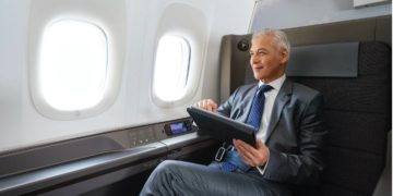 a man in a suit and tie holding a tablet