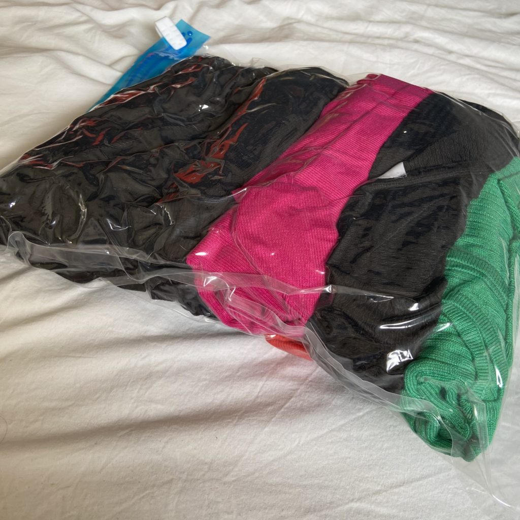 a bag of clothes on a bed