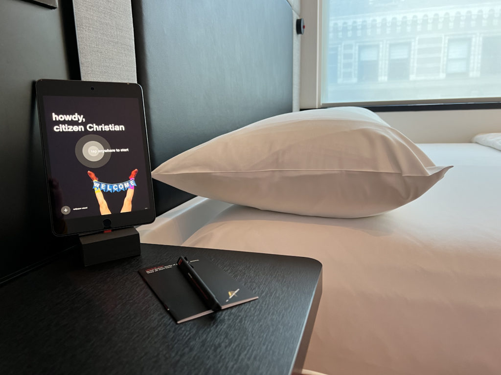 a tablet on a table next to a bed