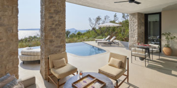 a pool and patio with chairs and a table