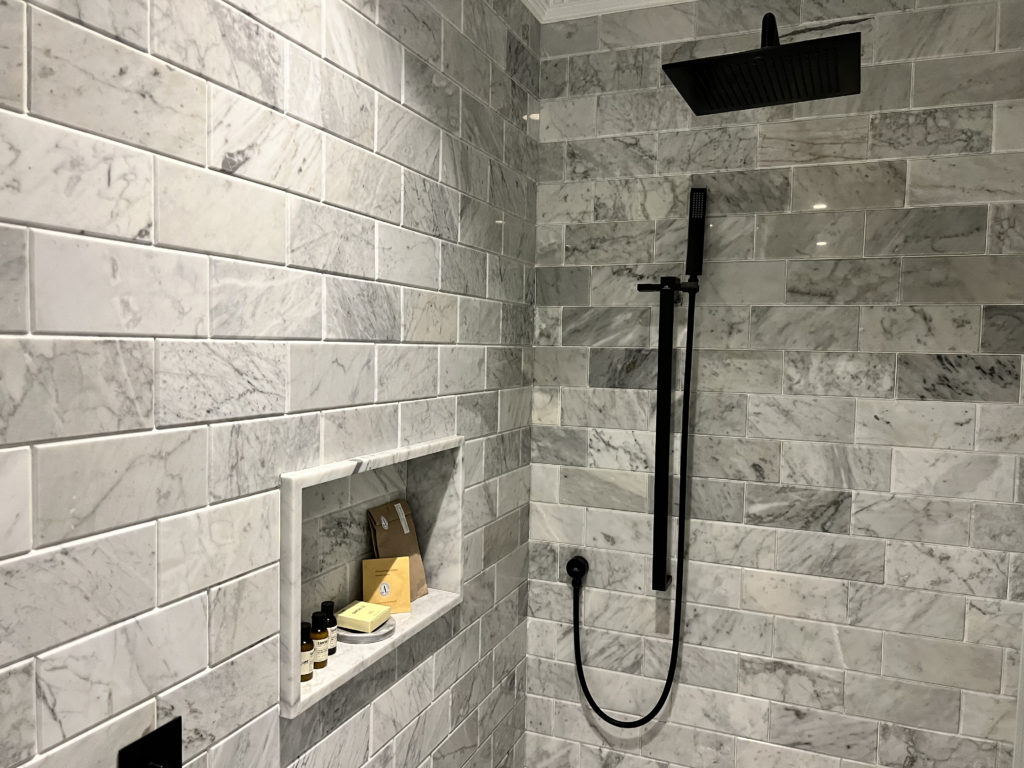 a shower with a black shower head