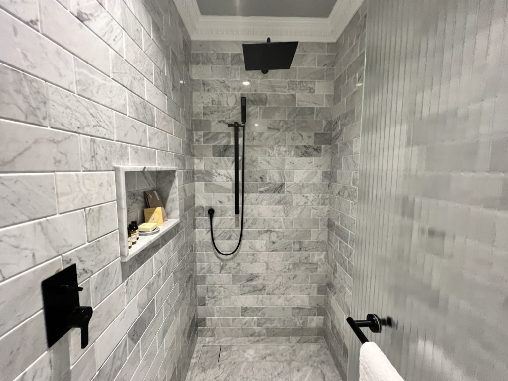 a shower with a black and white tile wall