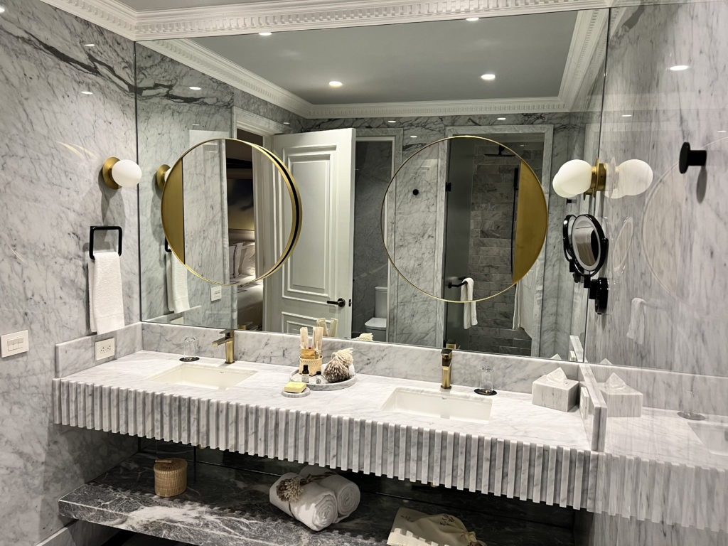 a bathroom with marble countertop sinks and mirrors