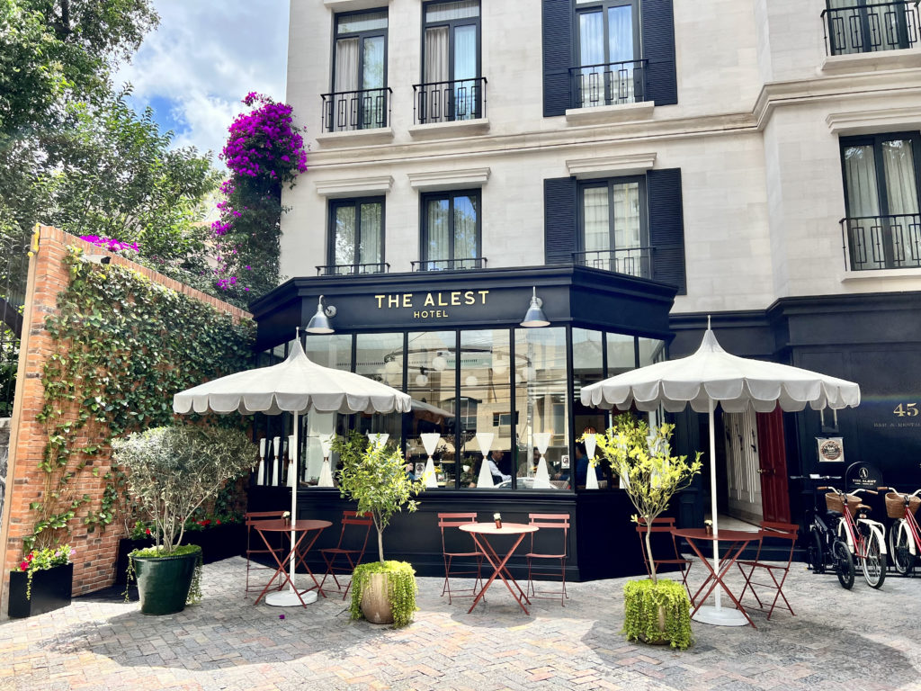 a building with a glass front with tables and umbrellas