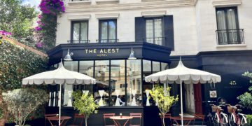 a building with a black awning and white umbrellas