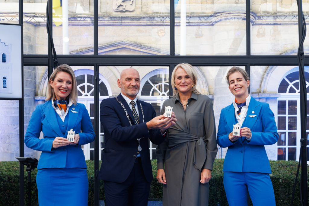 a group of people in blue suits holding small houses